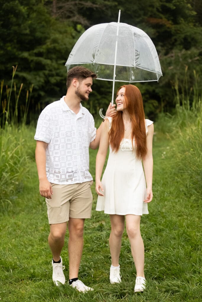 Couple walking underneath umbrella located at Cabell's Mill in Chantilly Virginia