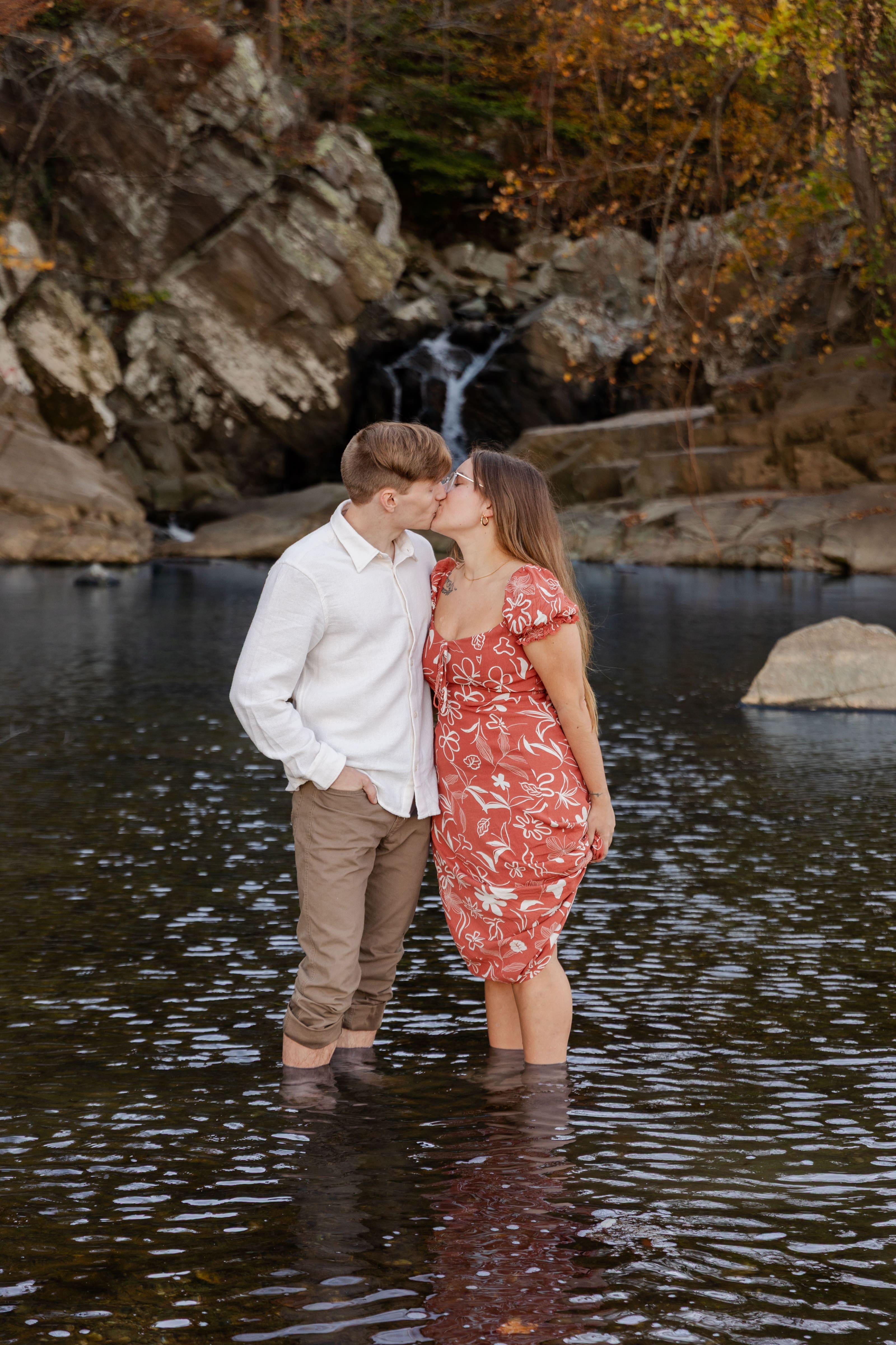 Scott's Run couple kissing in water with waterfall in background
